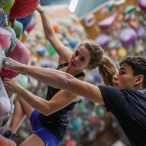 Grimpeur montrant une prise à une grimpeuse